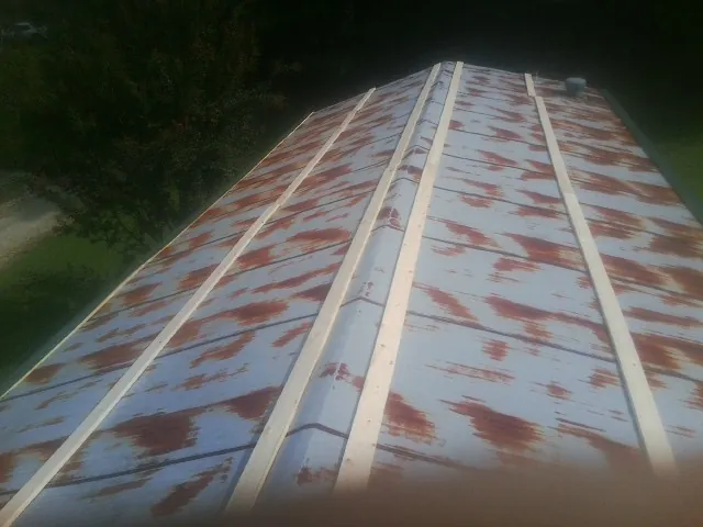 Rusted metal roof panels with new wood purlins before replacement — Storm Damage Roof Repair in Paragon by Roofing Brothers