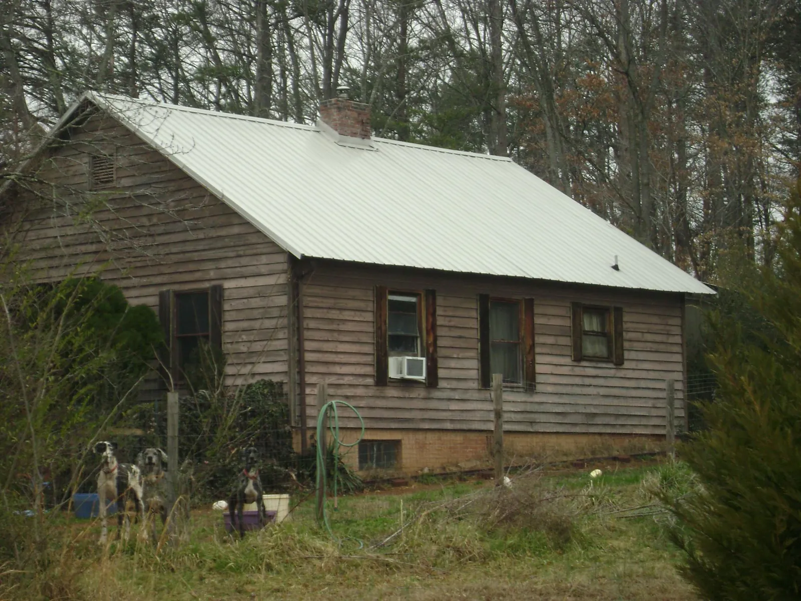 White metal roof on an old wood sided farmhouse, from a Metal Roof Installation job in Paragon